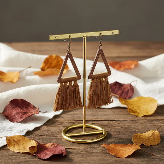 Brown triangle tassel earrings on a gold stand with a marble background