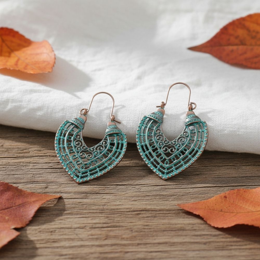 Turquoise earrings on a wooden surface with autumn leaves