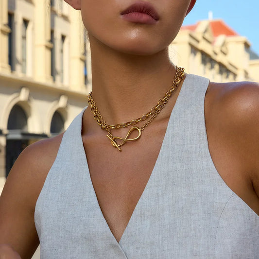 Woman wearing a gold necklace with a building in the background